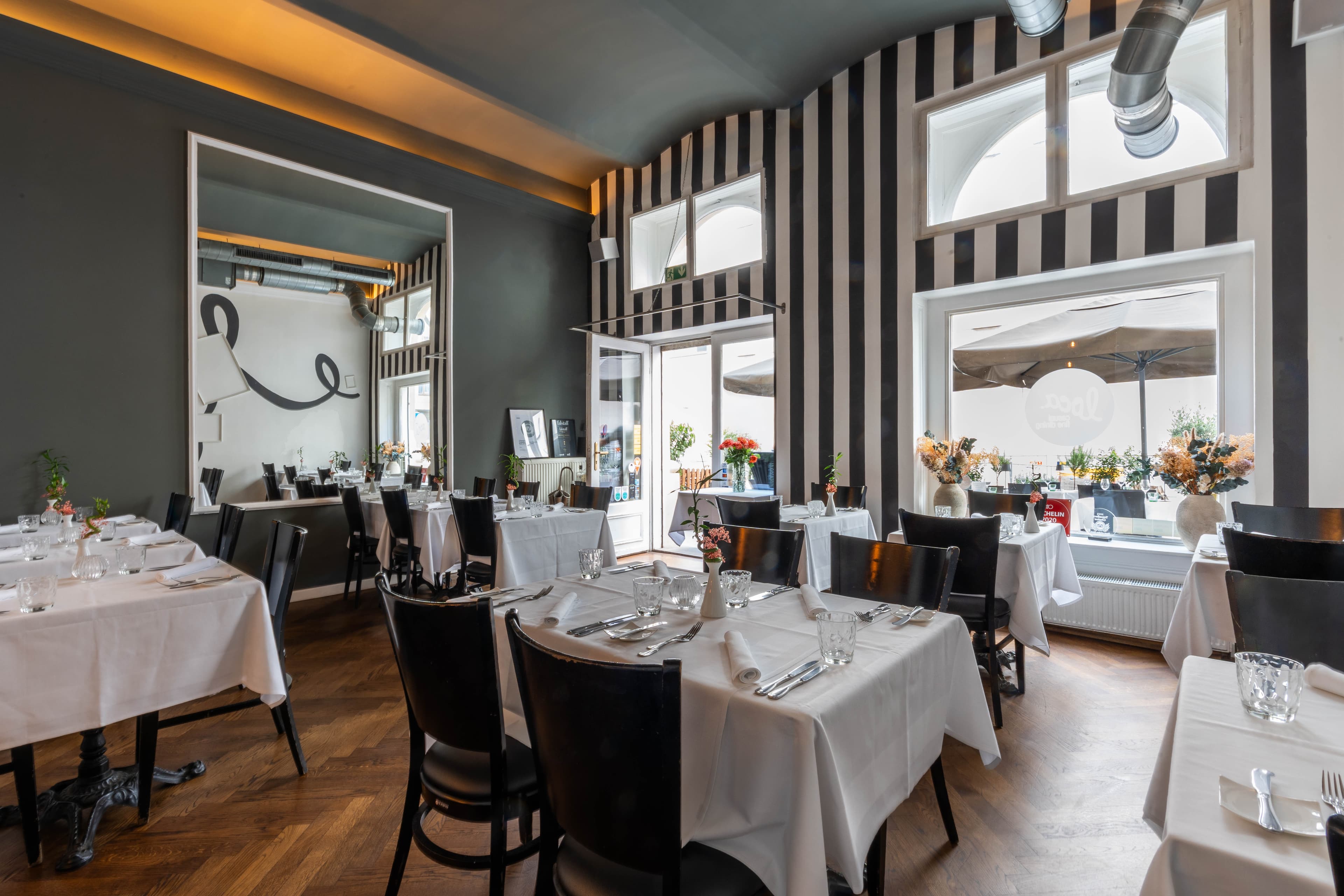 Das Restaurant Loca von innen — warme Lichtstimmung mit Streifenwand